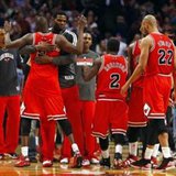 Luol Deng (arms raised) is hugged as he and his fellow Chicago Bulls players celebrate after beating the Miami Heat in an NBA basketball game at the United Center on March 27, 2013, 101-97. REUTERS/Jeff Haynes