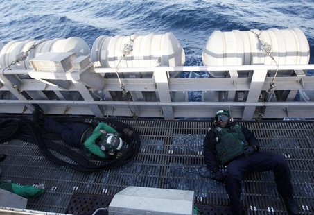 Sailors rest on the catwalk as they wait to refuel a helicopter on board the Nimitz-class aircraft carrier USS Abraham Lincoln (CVN 72) as i Sailors rest on the catwalk as they wait to refuel a helicopter on board the Nimitz-class aircraft carrier USS Abraham Lincoln (CVN 72) as i
