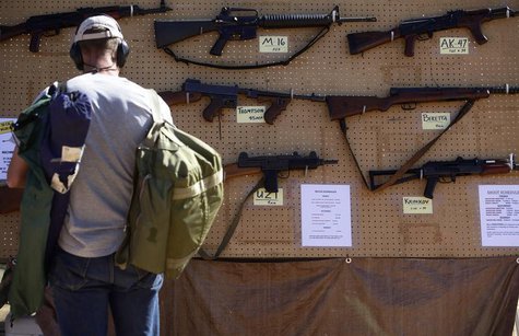 A man look at different rental guns displayed during the Big Sandy Shoot in Mohave County, Arizona March 22, 2013. REUTERS/Joshua Lott A man look at different rental guns displayed during the Big Sandy Shoot in Mohave County, Arizona March 22, 2013. REUTERS/Joshua Lott