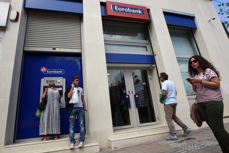 A woman (L) makes a transaction at an ATM machine outside a Eurobank branch in central Athens October 5, 2012. REUTERS/John Kolesidis A woman (L) makes a transaction at an ATM machine outside a Eurobank branch in central Athens October 5, 2012. REUTERS/John Kolesidis