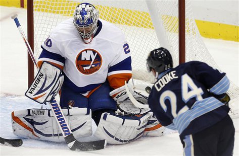 Pittsburgh Penguins' Matt Cooke (24) scores against the New York Islanders goalie Evgeni Nabokov (20) in the third period of their NHL hocke Pittsburgh Penguins' Matt Cooke (24) scores against the New York Islanders goalie Evgeni Nabokov (20) in the third period of their NHL hocke