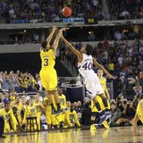 Michigan Wolverines guard Trey Burke shoots a three point basket over Kansas Jayhawks forward Kevin Young to tie the game during the second half in their South Regional NCAA men's basketball game in Arlington, Texas March 29, 2013. REUTERS/Mike Stone (UNITED STATES - Tags: SPORT BASKETBALL)
Photo: REUTERS