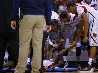 Louisville Cardinals players hold hands with Kevin Ware (5) after he broke his leg in the first half against the Duke Blue Devils during the Louisville Cardinals players hold hands with Kevin Ware (5) after he broke his leg in the first half against the Duke Blue Devils during the