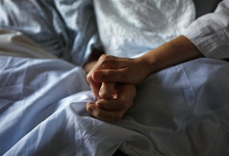 A woman holds the hand of her mother who is dying from cancer during her final hours at a palliative care hospital in Winnipeg July 24, 2010 A woman holds the hand of her mother who is dying from cancer during her final hours at a palliative care hospital in Winnipeg July 24, 2010