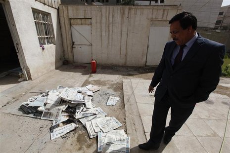 An Iraqi journalist walks past the archive newspapers burned after attack by an armed group at the newspaper's headquarters of Addustour new An Iraqi journalist walks past the archive newspapers burned after attack by an armed group at the newspaper's headquarters of Addustour new