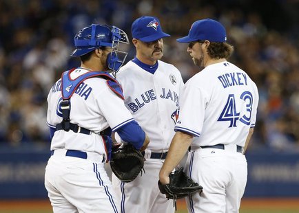 Toronto Blue Jays pitching coach Pete Walker (C) talks with starting pitcher R.A. Dickey and catcher J.P. Arencibia during the sixth inning Toronto Blue Jays pitching coach Pete Walker (C) talks with starting pitcher R.A. Dickey and catcher J.P. Arencibia during the sixth inning