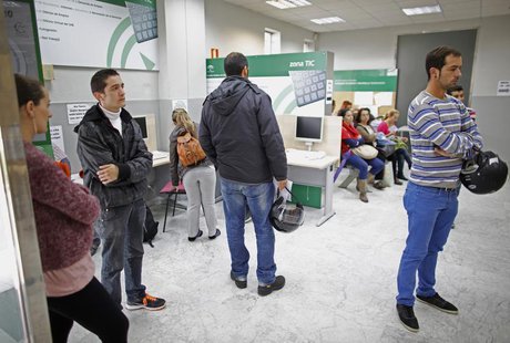 Jesus Pardal (2nd L), an unemployed 29-year-old father-to-be, waits inside a government-run employment office with wife Yolanda Garcia (L), Jesus Pardal (2nd L), an unemployed 29-year-old father-to-be, waits inside a government-run employment office with wife Yolanda Garcia (L),