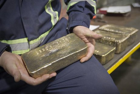 A worker holds a polished gold alloy bar in a workshop at Kumtor gold mine extraction factory in the Tien Shan mountains, some 350 kilometre A worker holds a polished gold alloy bar in a workshop at Kumtor gold mine extraction factory in the Tien Shan mountains, some 350 kilometre