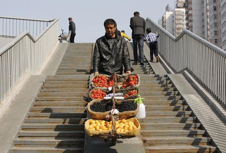 A street vendor pushes his mobile fruit stall on a pedestrian overpass in Beijing March 22, 2013. REUTERS/Kim Kyung-Hoon A street vendor pushes his mobile fruit stall on a pedestrian overpass in Beijing March 22, 2013. REUTERS/Kim Kyung-Hoon