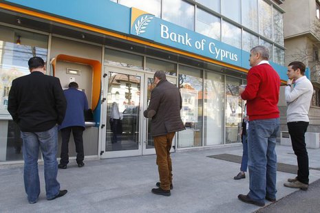 People wait in front of a branch of Bank of Cyprus to withdraw money from its ATM in Bucharest April 1, 2013. REUTERS/Bogdan Cristel People wait in front of a branch of Bank of Cyprus to withdraw money from its ATM in Bucharest April 1, 2013. REUTERS/Bogdan Cristel
