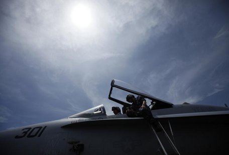 Crew members work on the cockpit of a F/A-18C fighter jet on the deck of the USS Ronald Reagan (CVN76) in Hong Kong August 12, 2011. REUTERS Crew members work on the cockpit of a F/A-18C fighter jet on the deck of the USS Ronald Reagan (CVN76) in Hong Kong August 12, 2011. REUTERS
