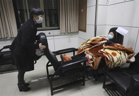 A patient with fever (R) is accompanied by a family member while receiving treatment at the hospital where a 67-year-old H7N9 patient is bei A patient with fever (R) is accompanied by a family member while receiving treatment at the hospital where a 67-year-old H7N9 patient is bei