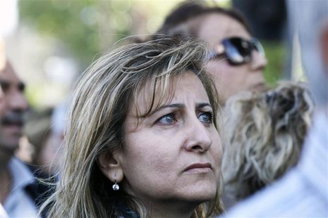 A woman looks on as she joins other Cypriot bank workers during a protest against the possibility of their pensions being affected should th A woman looks on as she joins other Cypriot bank workers during a protest against the possibility of their pensions being affected should th