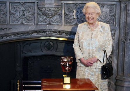Britain's Queen Elizabeth poses with her honorary British Academy of Film and Arts (BAFTA) award, after receiving it from actor Kenneth Bran Britain's Queen Elizabeth poses with her honorary British Academy of Film and Arts (BAFTA) award, after receiving it from actor Kenneth Bran