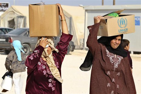 Syrian refugees carry aid and ration at the Zaatari refugee camp in the Jordanian city of Mafraq, near the border with Syria October 22, 201 Syrian refugees carry aid and ration at the Zaatari refugee camp in the Jordanian city of Mafraq, near the border with Syria October 22, 201