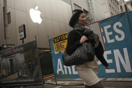 A woman walks past an Apple logo at the company's flagship retail store near signs for the central subway project in San Francisco, Californ A woman walks past an Apple logo at the company's flagship retail store near signs for the central subway project in San Francisco, Californ