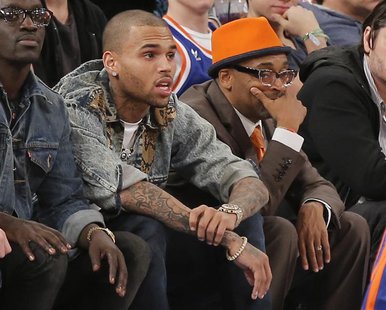 Entertainer Chris Brown watches next to film director Spike Lee (R) as the New York Knicks play the Boston Celtics in the third quarter of t Entertainer Chris Brown watches next to film director Spike Lee (R) as the New York Knicks play the Boston Celtics in the third quarter of t
