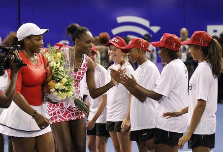 U.S. tennis players Serena Williams (L) and her sister Venus greet children at the end of their exhibit tennis match in Johannesburg Novembe U.S. tennis players Serena Williams (L) and her sister Venus greet children at the end of their exhibit tennis match in Johannesburg Novembe