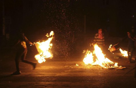 A protester prepares to throw a burning object at the High Court's entrance during clashes with police in front of the court in Cairo April A protester prepares to throw a burning object at the High Court's entrance during clashes with police in front of the court in Cairo April