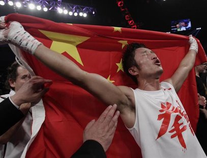 China's Zou Shiming, two-time Olympic gold medal winner and three-time World Amateur Champion, celebrates his win with a Chinese national fl China's Zou Shiming, two-time Olympic gold medal winner and three-time World Amateur Champion, celebrates his win with a Chinese national fl