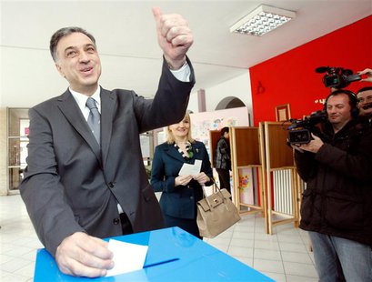 Montenegrin President Filip Vujanovic (L), accompanied with his wife Svetlana, gestures as he casts his vote during Montenegro's presidental Montenegrin President Filip Vujanovic (L), accompanied with his wife Svetlana, gestures as he casts his vote during Montenegro's presidental