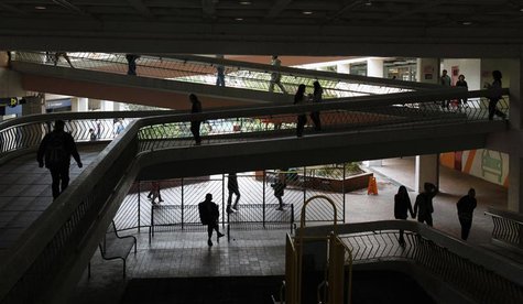A resident rests as others walk inside footbridges at Choi Wan public housing estate, where a 61-year-old woman Lam Mei-ling who is involvin A resident rests as others walk inside footbridges at Choi Wan public housing estate, where a 61-year-old woman Lam Mei-ling who is involvin
