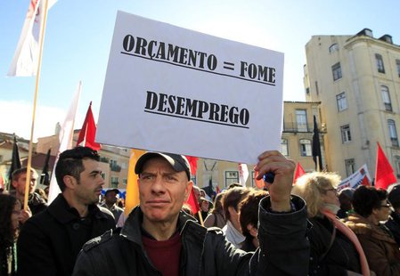 A man holds a sign reading: "Budget = hunger, unemployment" during an anti-austerity protest in front of Portugal's parliament in Lisbon Nov A man holds a sign reading: "Budget = hunger, unemployment" during an anti-austerity protest in front of Portugal's parliament in Lisbon Nov