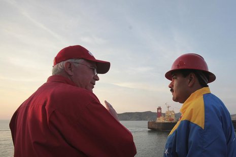 Venezuela's acting President Nicolas Maduro (R) listens to Energy Minister Rafael Ramirez during a meeting with oil workers in the port of G Venezuela's acting President Nicolas Maduro (R) listens to Energy Minister Rafael Ramirez during a meeting with oil workers in the port of G