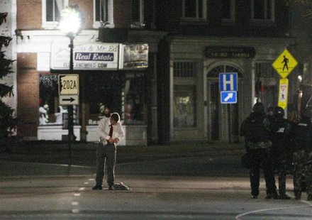 A suspect identified by authorities as Leeland Eisenberg unstraps items from his body as he gives himself up to police outside Democratic pr A suspect identified by authorities as Leeland Eisenberg unstraps items from his body as he gives himself up to police outside Democratic pr