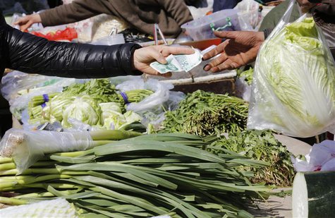 A woman pays for vegetables at a morning market in Beijing April 8, 2013. REUTERS/Kim Kyung-Hoon A woman pays for vegetables at a morning market in Beijing April 8, 2013. REUTERS/Kim Kyung-Hoon