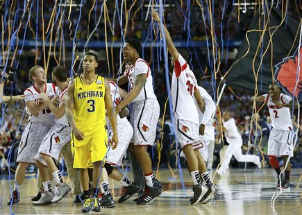 The Louisville Cardinals celebrate as Michigan Wolverines guard Trey Burke (3) leaves the court after Louisville won the NCAA men's Final Fo The Louisville Cardinals celebrate as Michigan Wolverines guard Trey Burke (3) leaves the court after Louisville won the NCAA men's Final Fo