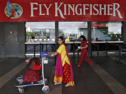 A passenger walks with her luggage in front of a Kingfisher Airlines reservation office at the domestic airport in Mumbai October 23, 2012. A passenger walks with her luggage in front of a Kingfisher Airlines reservation office at the domestic airport in Mumbai October 23, 2012.
