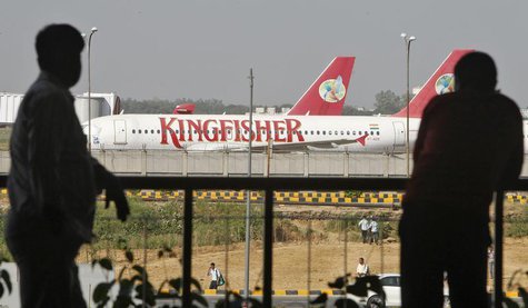 People are silhouetted as Kingfisher Airlines' aircrafts are seen parked at an airport in New Delhi October 1, 2012. REUTERS/Mansi Thapliyal People are silhouetted as Kingfisher Airlines' aircrafts are seen parked at an airport in New Delhi October 1, 2012. REUTERS/Mansi Thapliyal