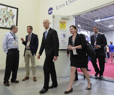 Florida Governor Rick Scott (C) leaves one of the media facilities after finishing an interview before Republican presidential nominee Mitt Florida Governor Rick Scott (C) leaves one of the media facilities after finishing an interview before Republican presidential nominee Mitt