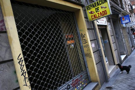 A dog waits for its owner next to a closed down business in Madrid March 27, 2013. REUTERS/Susana Vera A dog waits for its owner next to a closed down business in Madrid March 27, 2013. REUTERS/Susana Vera