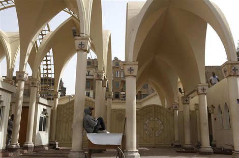 A Coptic Christian sits on a desk near the gate inside Cairo's main Coptic cathedral, following Sunday's clashes with Muslims, April 8, 2013 A Coptic Christian sits on a desk near the gate inside Cairo's main Coptic cathedral, following Sunday's clashes with Muslims, April 8, 2013