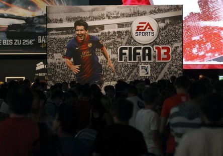 Visitors walk past an advertising placard of FIFA13 during the Gamescom 2012 fair in Cologne August 16, 2012. REUTERS/Ina Fassbender Visitors walk past an advertising placard of FIFA13 during the Gamescom 2012 fair in Cologne August 16, 2012. REUTERS/Ina Fassbender