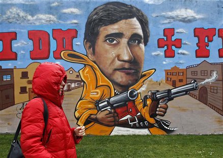 A woman walks past a wall with a graffiti of Portugal's Prime Minister Pedro Passos Coelho in Lisbon April 9, 2013. REUTERS/Jose Manuel Ribe A woman walks past a wall with a graffiti of Portugal's Prime Minister Pedro Passos Coelho in Lisbon April 9, 2013. REUTERS/Jose Manuel Ribe