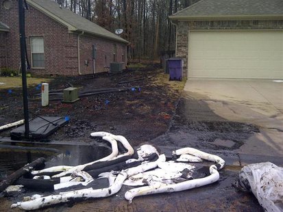 Spilt oil from Exxon pipeline runs between homes in North Woods Subdivision in Mayflower, Arkansas in this March 31, 2013 photo released to Spilt oil from Exxon pipeline runs between homes in North Woods Subdivision in Mayflower, Arkansas in this March 31, 2013 photo released to