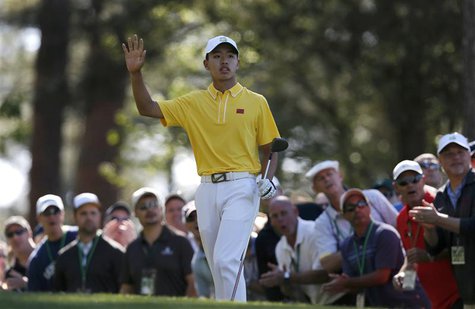 Amateur Guan Tianlang of China waves after hitting his tee shot on the fourth hole during third round play in the 2013 Masters golf tourname Amateur Guan Tianlang of China waves after hitting his tee shot on the fourth hole during third round play in the 2013 Masters golf tourname