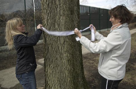 Carla Sloan (R) and Liz Ziehl, friends and neighbors of diplomat Anne Smedinghoff, 25, tie a ribbon on a tree in River Forest, Illinois, Apr Carla Sloan (R) and Liz Ziehl, friends and neighbors of diplomat Anne Smedinghoff, 25, tie a ribbon on a tree in River Forest, Illinois, Apr