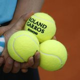 A ball boy holds tennis balls during an exhibition match ahead of the French Open tennis tournament at the Roland Garros stadium in Paris Ma