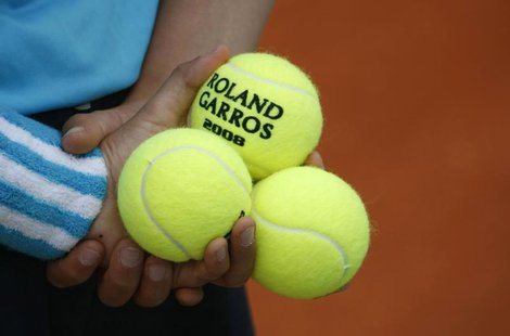 A ball boy holds tennis balls during an exhibition match ahead of the French Open tennis tournament at the Roland Garros stadium in Paris Ma A ball boy holds tennis balls during an exhibition match ahead of the French Open tennis tournament at the Roland Garros stadium in Paris Ma