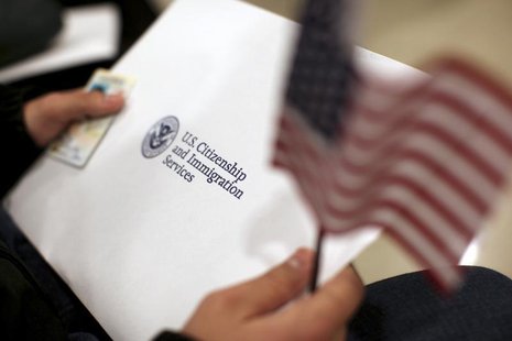 A man holds a U.S. flag while receiving his proof of U.S. citizenship during a ceremony in San Francisco, California January 30, 2013. REUTE A man holds a U.S. flag while receiving his proof of U.S. citizenship during a ceremony in San Francisco, California January 30, 2013. REUTE