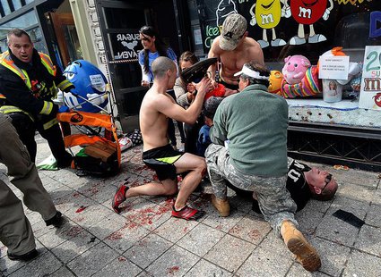 Bystanders tend to an injured man following explosions at the Boston Marathon in Boston, Massachusetts, April 15, 2013. REUTERS/MetroWest Da Bystanders tend to an injured man following explosions at the Boston Marathon in Boston, Massachusetts, April 15, 2013. REUTERS/MetroWest Da