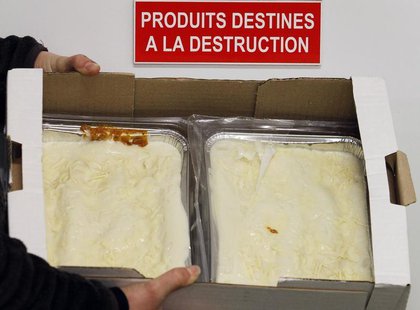An employee displays a case of frozen beef lasagne dinners, removed from stores and prepared for destruction, under a sign on a door which r An employee displays a case of frozen beef lasagne dinners, removed from stores and prepared for destruction, under a sign on a door which r
