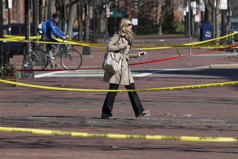 A commuter walks between police tapes a day after explosions hit the Boston Marathon in Boston, Massachusetts on April 16, 2013. REUTERS/Adr A commuter walks between police tapes a day after explosions hit the Boston Marathon in Boston, Massachusetts on April 16, 2013. REUTERS/Adr