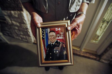Wilburn Russell, 73, displays a portrait of his son, Sergeant John M. Russell, the Army sergeant who is accused of killing five fellow soldi Wilburn Russell, 73, displays a portrait of his son, Sergeant John M. Russell, the Army sergeant who is accused of killing five fellow soldi
