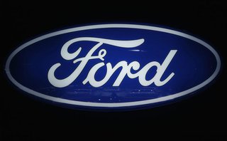 Ford cars are reflected in the company's logo at the carmakers' booth on media day at the Paris Mondial de l'Automobile, September 28, 2012.