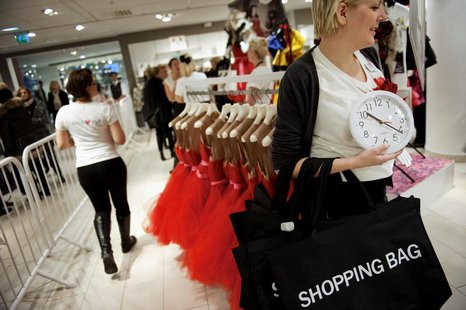 A shopper holds a clock as she walks in the cordoned-off area of a Swedish fashion giant H&M store in Stockholm November 23, 2010. REUTERS/J A shopper holds a clock as she walks in the cordoned-off area of a Swedish fashion giant H&M store in Stockholm November 23, 2010. REUTERS/J